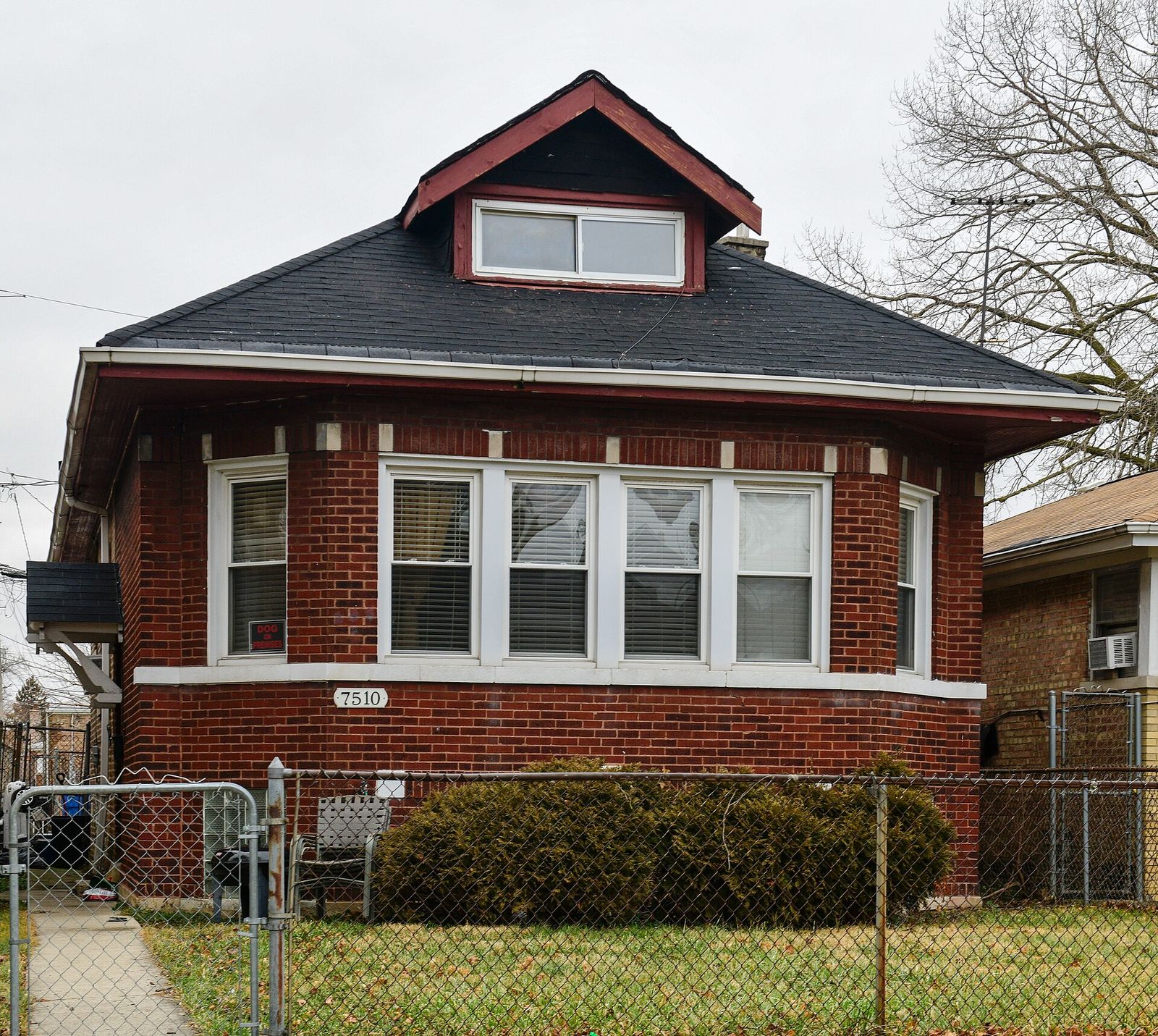 Red brick Chicago bungalow with a dark shingle roof